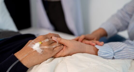 A patient holding hands with a loved one.