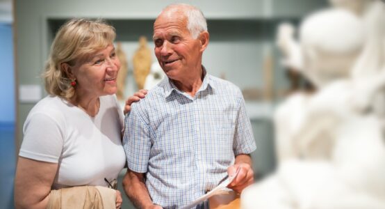 A couple looking at a statue in a museum.