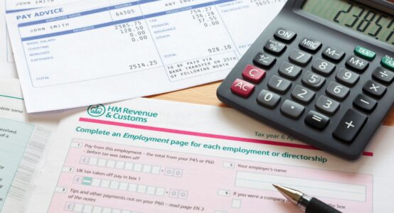 Paperwork relating to a tax return, with calculator and pen lying on it