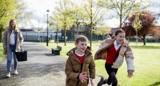 A mum and two children walking home from school.