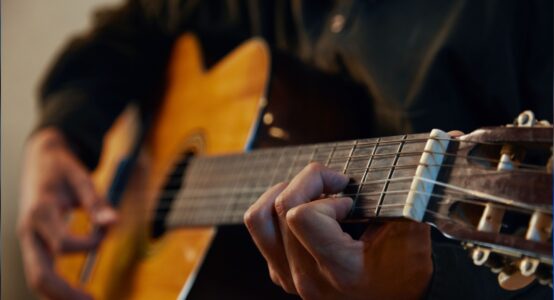 A close-up of someone playing a guitar.