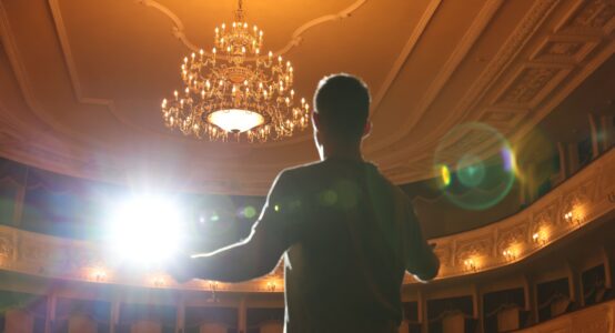 An actor rehearsing on a theatre stage.