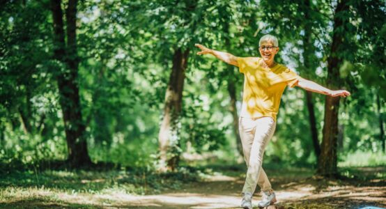 A woman doing balancing exercises outdoors.