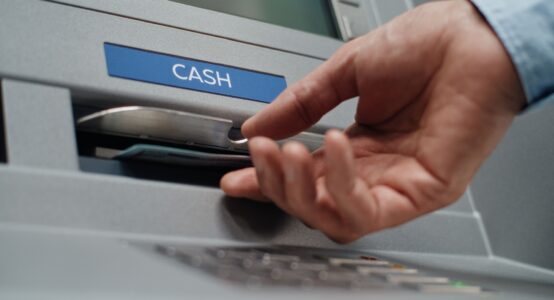 A person using an ATM to withdraw cash.