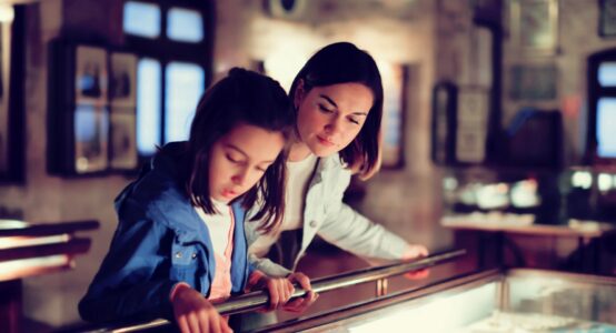 A mother and daughter viewing a museum exhibit.