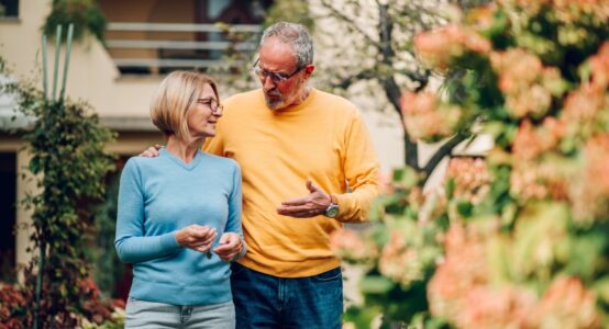 Mature couple walking outside a house