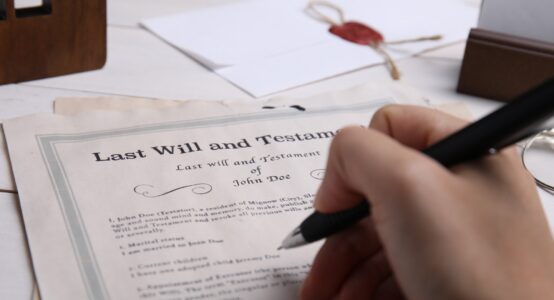 A person signing a will.