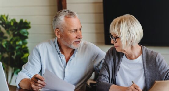 A mature couple talking and looking at paperwork together